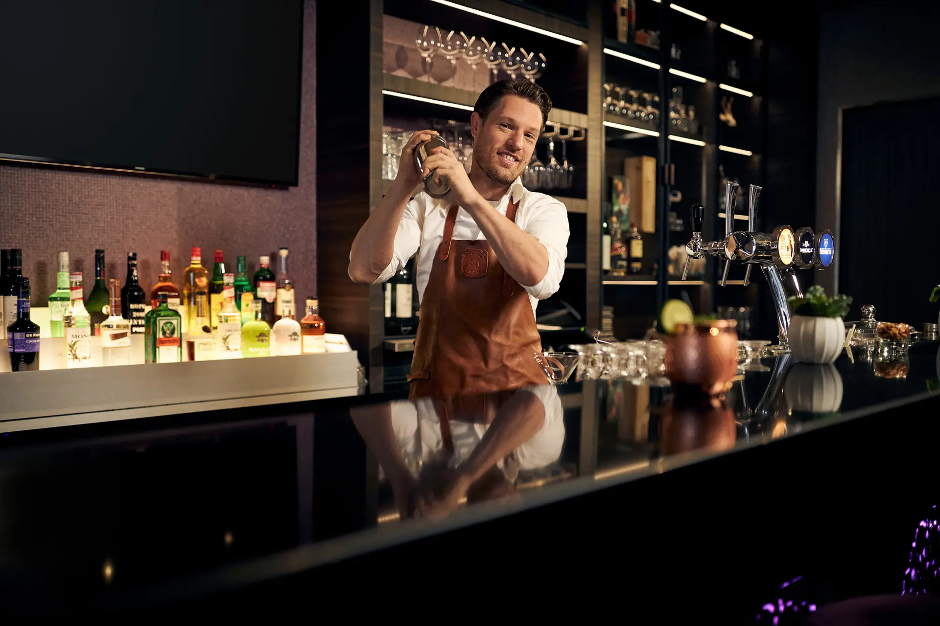Barman die een cocktail bereidt achter de bar