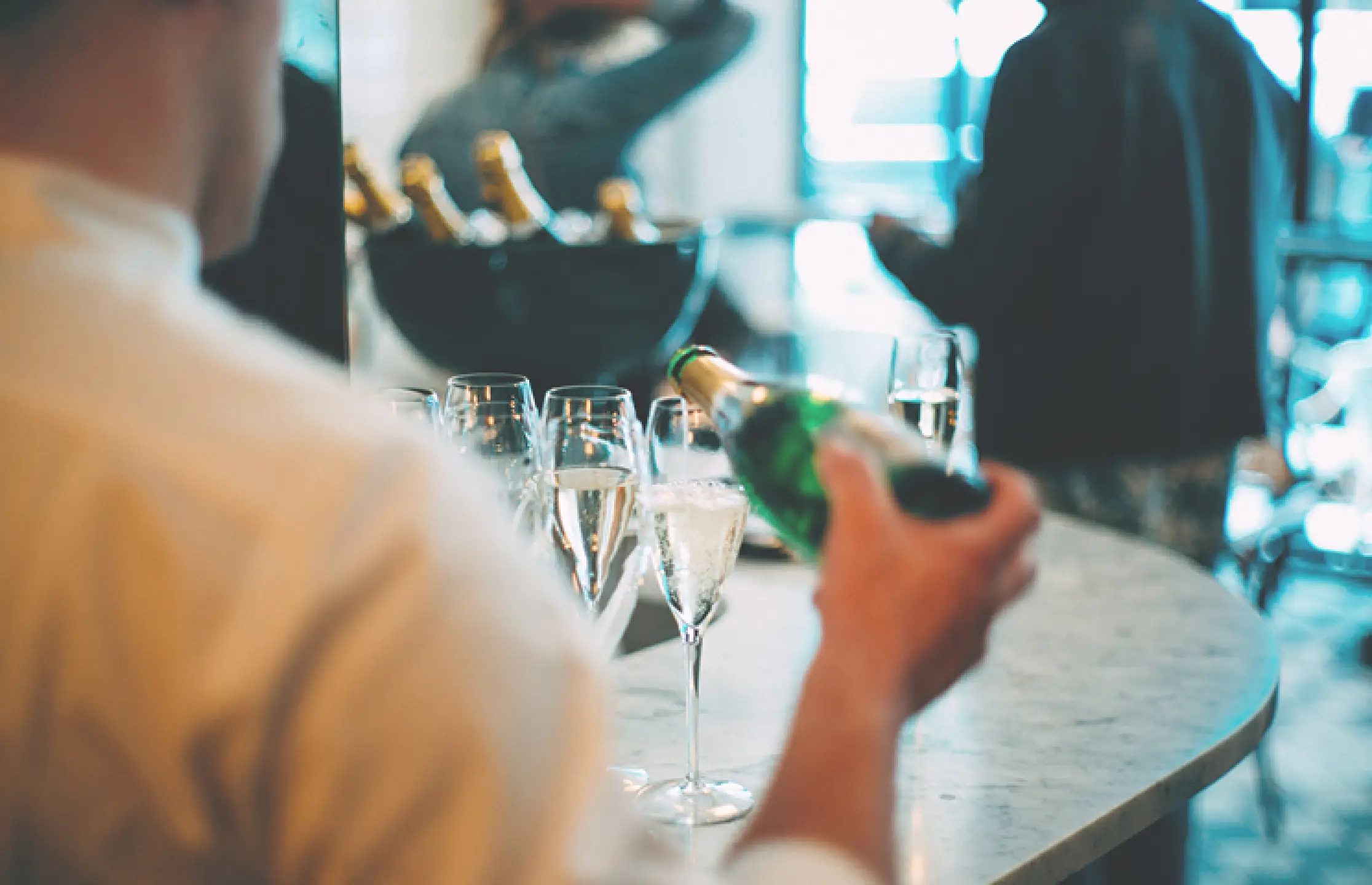 Barmedewerker schenkt champagne in glazen