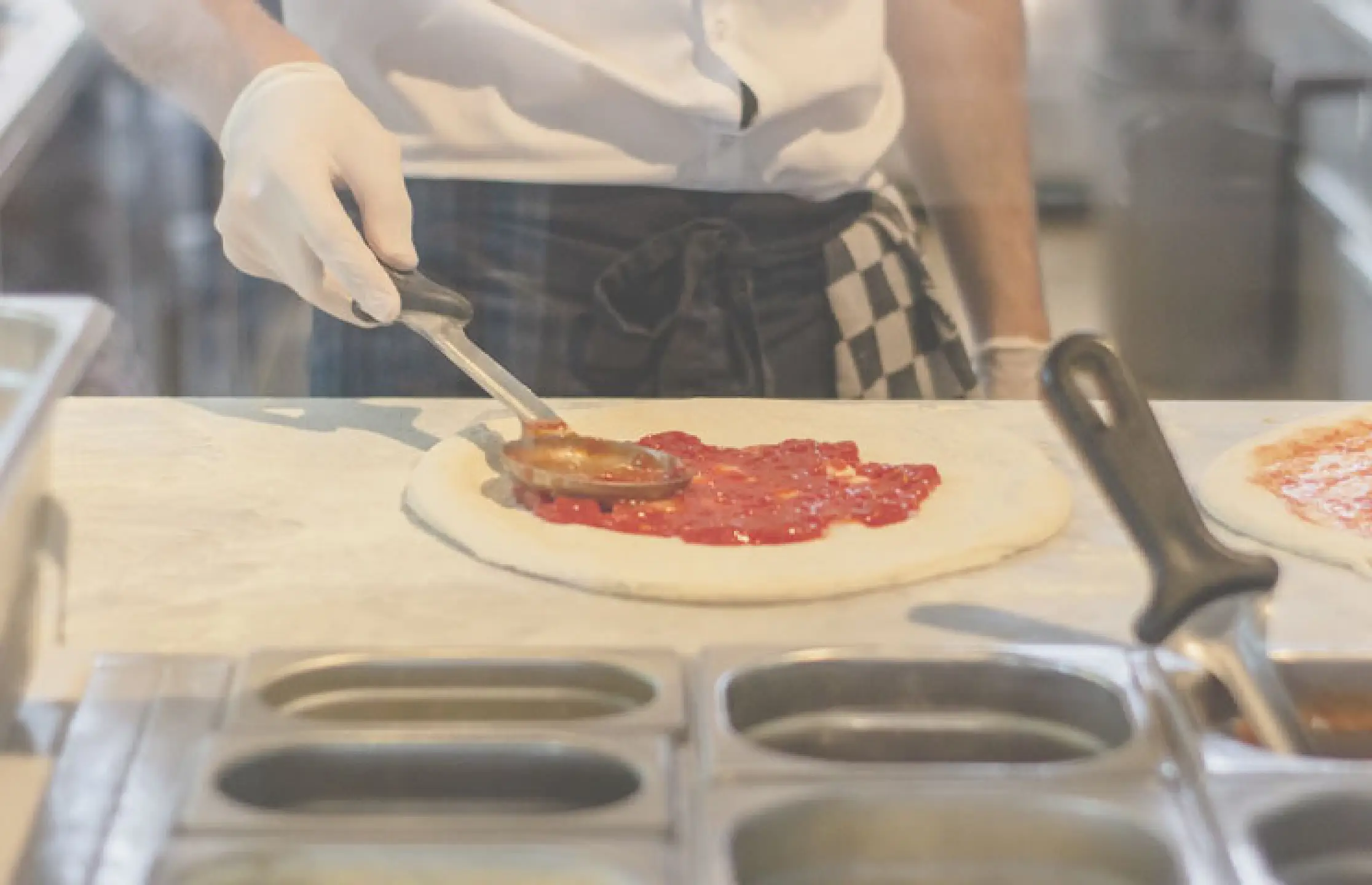 Kok belegt pizza in keuken restaurant