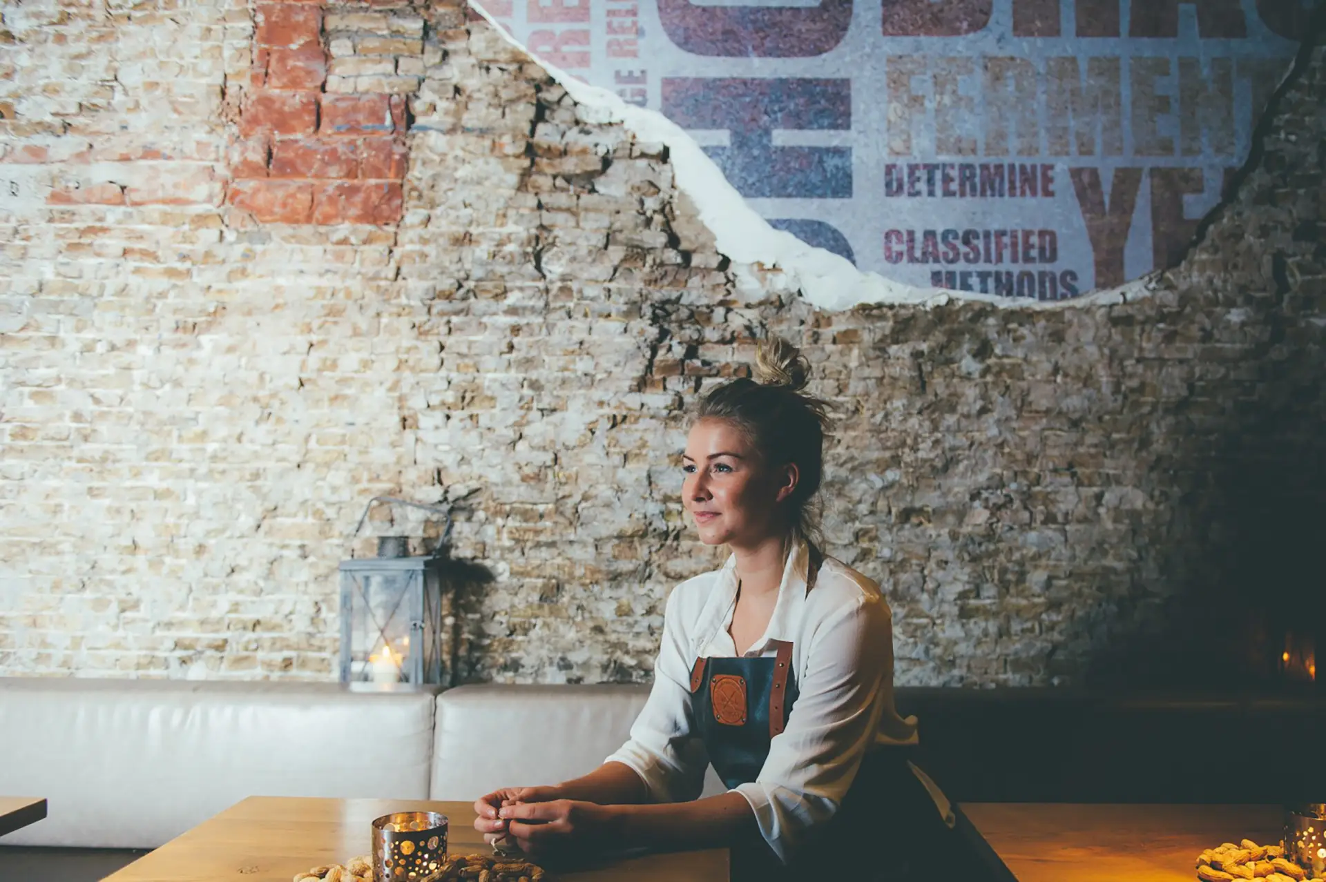 Lachende vrouw voor een stenen muur in een restaurant