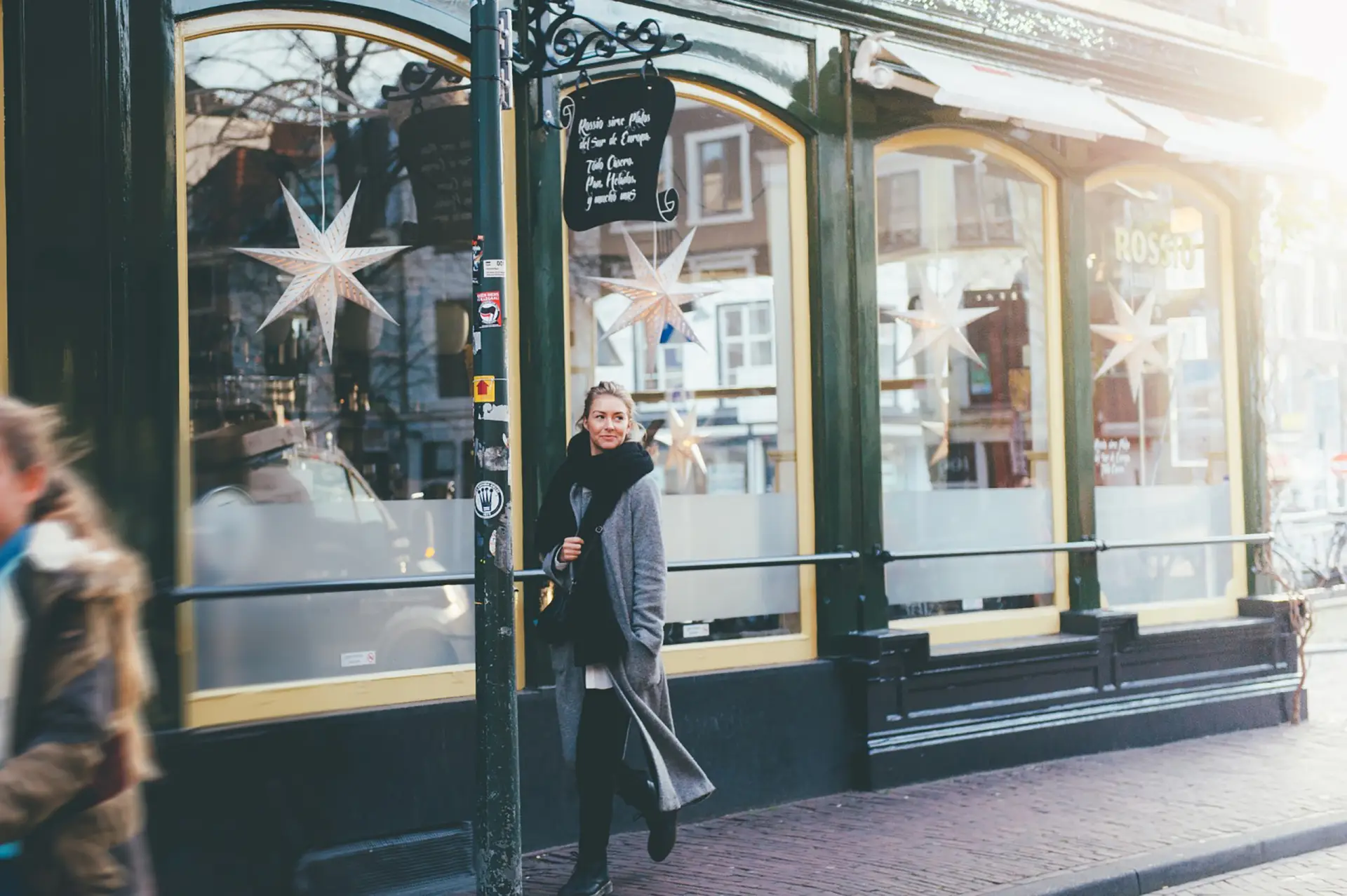 Lopende vrouw in de stad voor een winkel met sterren in de etalage