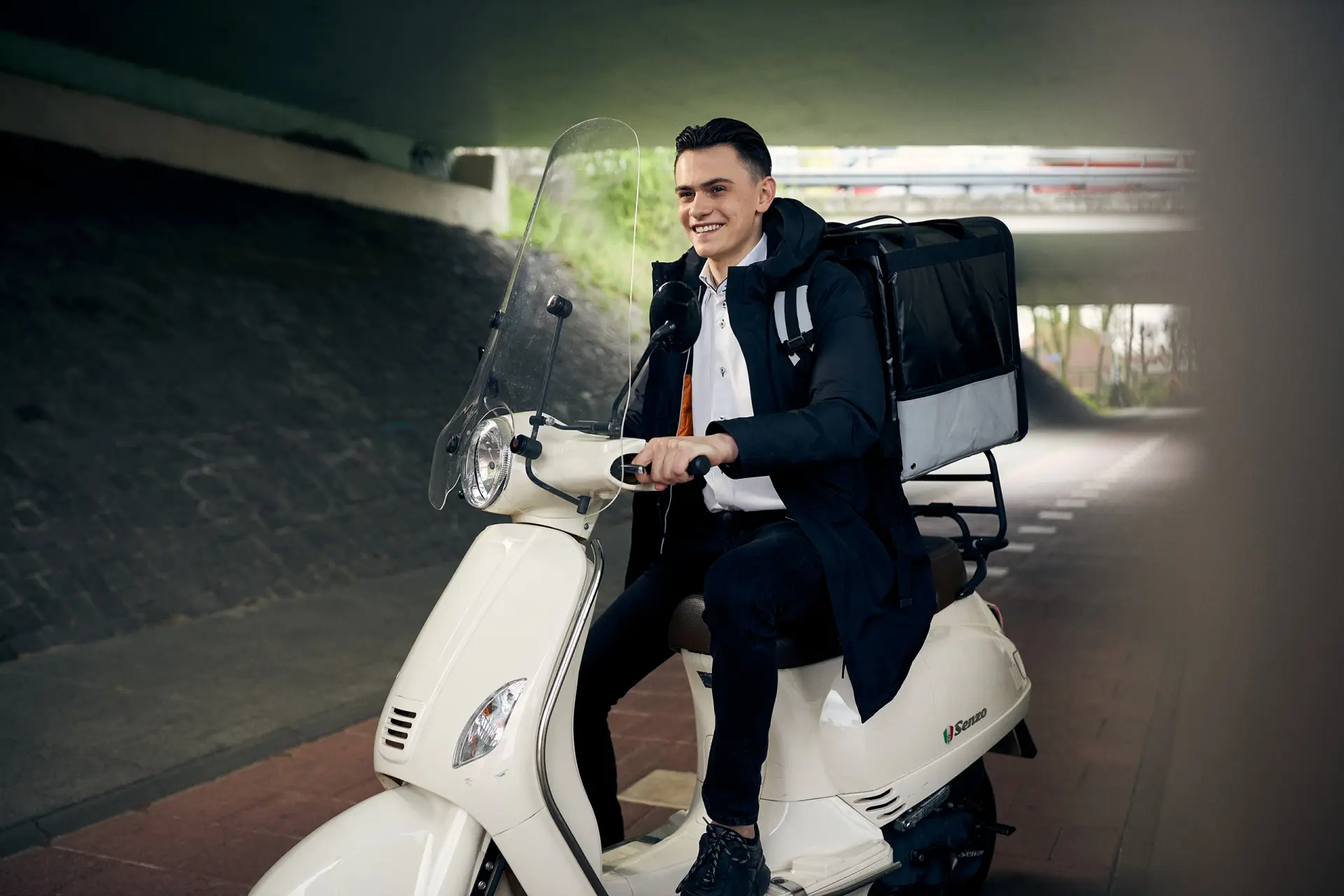 Mannelijke bezorger op een scooter met een grote bezorgtas