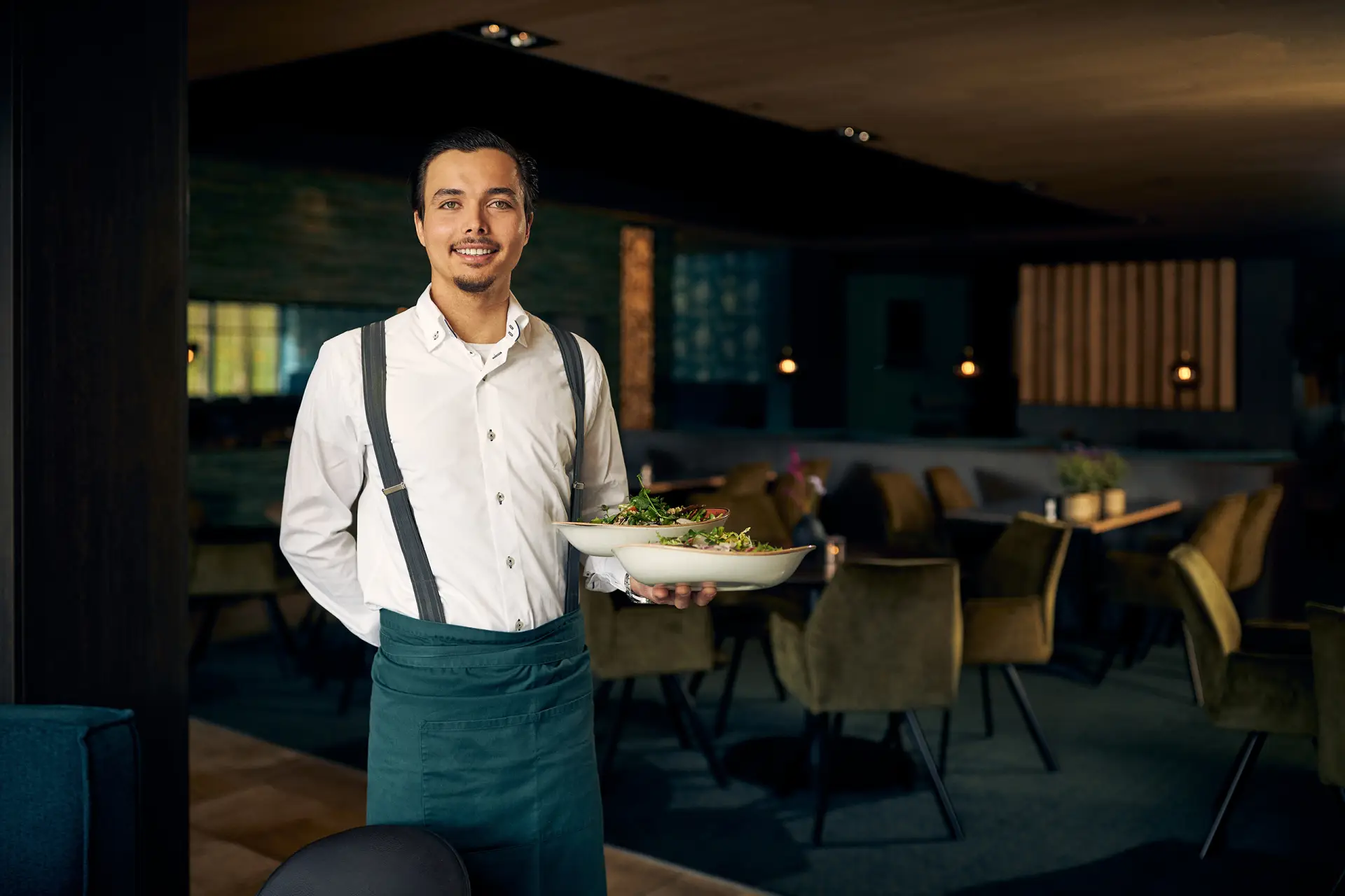 Mannelijke ober met een bord eten in een restaurant