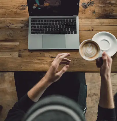 Medewerker volgt online training en drinkt ondertussen een kop koffie