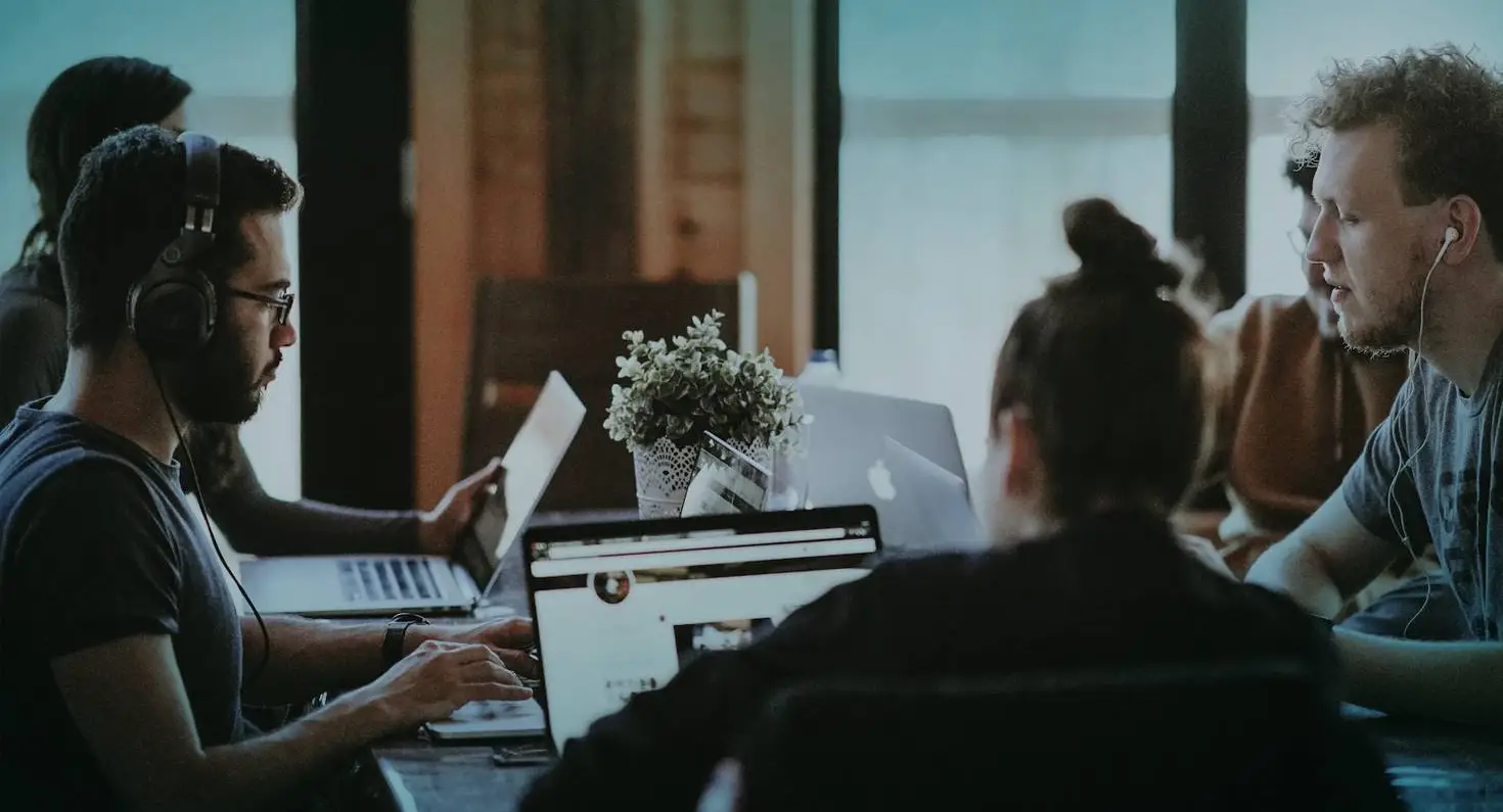 mensen werkend achter een laptop aan tafel