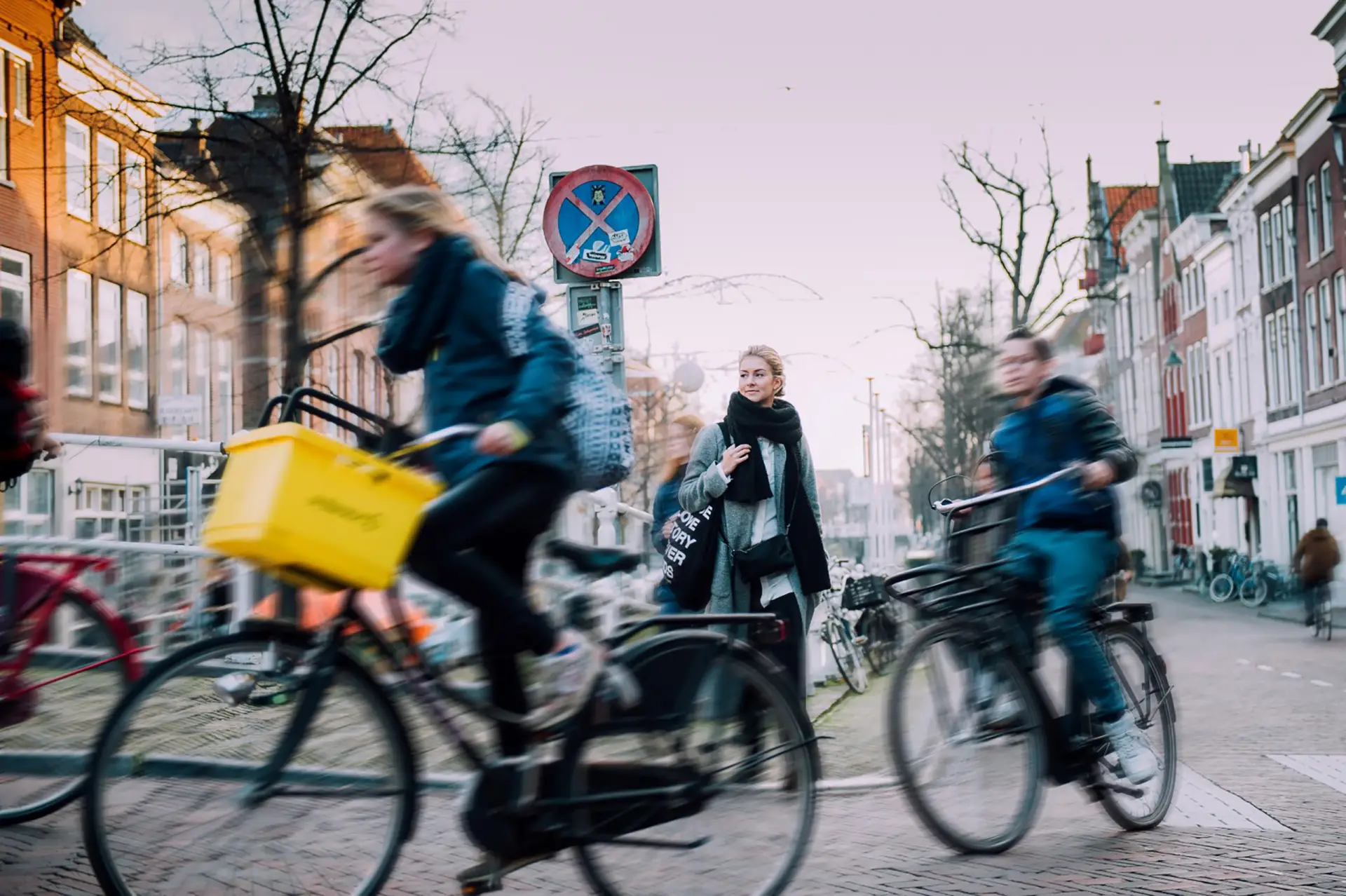 Vrouw die tussen de fietsers doorloopt in de stad
