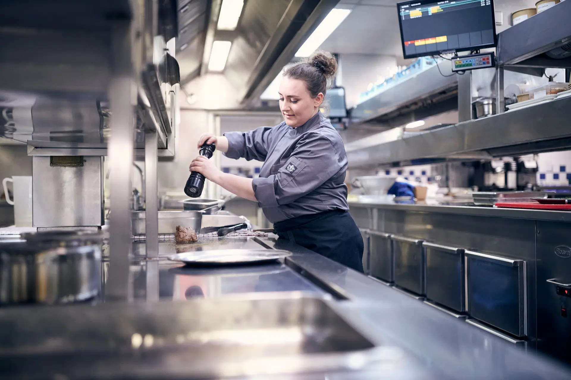 Vrouwelijke kok in een industriële keuken