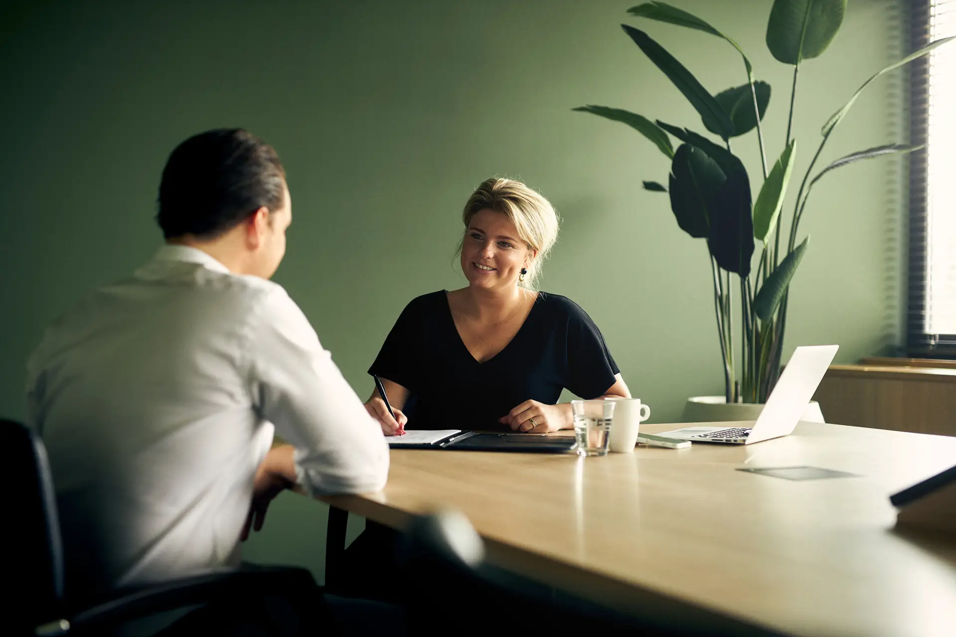 Vrouwelijke medewerker die een mannelijke medewerker coacht in een vergaderruimte